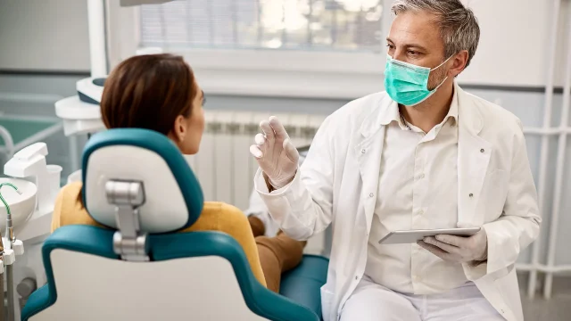 dentist-explains-procedure-to-woman-patient-2026-03-16-03-30-36-utc copia