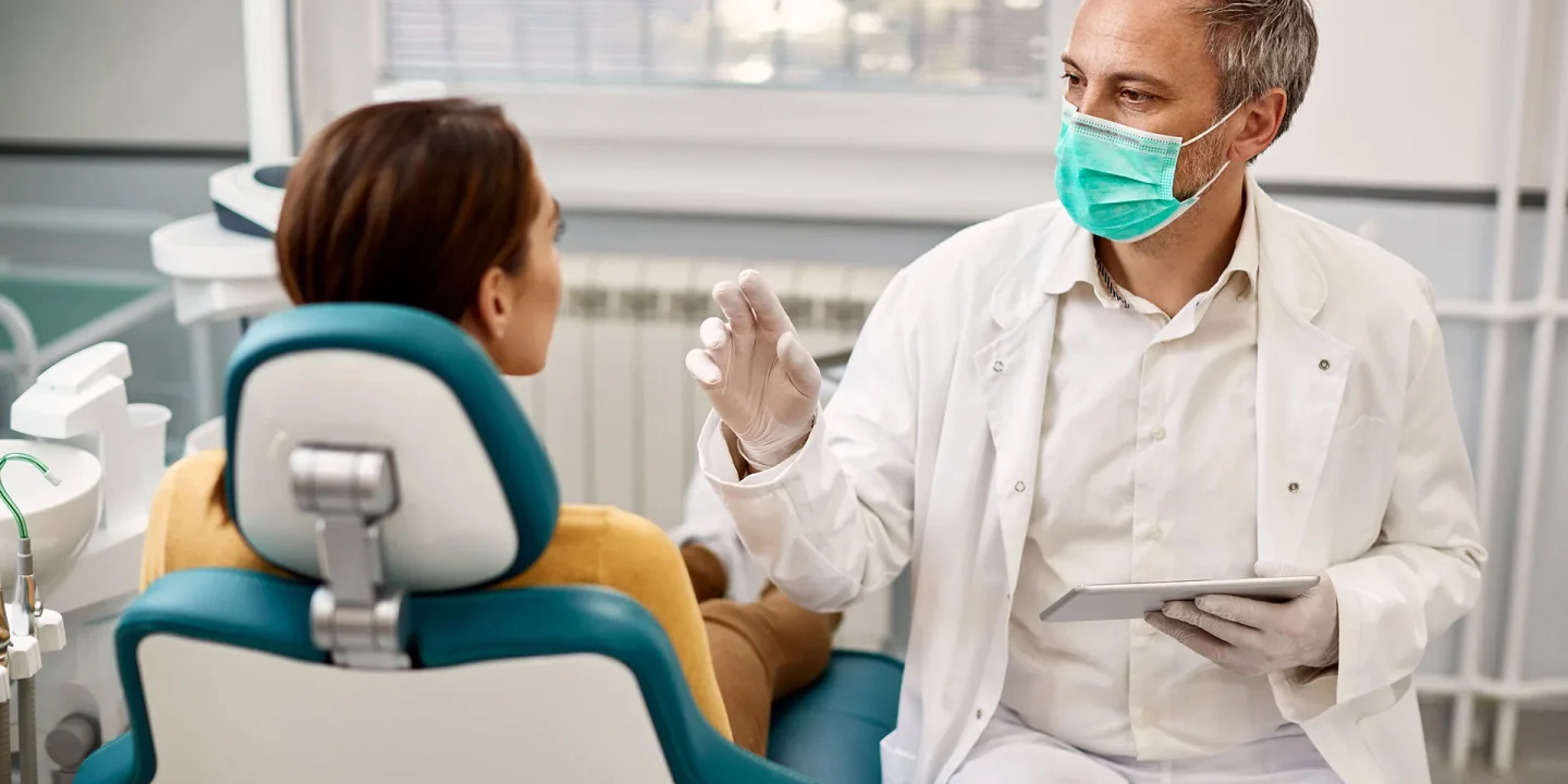 dentist-explains-procedure-to-woman-patient-2026-03-16-03-30-36-utc copia